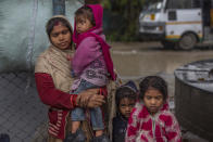 Indian migrant laborer Gunjan Kumari with her daughters waits at a government transport yard trying to leave for their homes in Srinagar, Indian controlled Kashmir on Oct. 18, 2021. A spate of recent killings has rattled Indian-controlled Kashmir, with violence targeting local minority members and Indian civilians from outside the disputed region. Assailants shot and killed five Indian migrant workers this month increasing the death toll in targeted killings to 32 this year. (AP Photo/Dar Yasin)