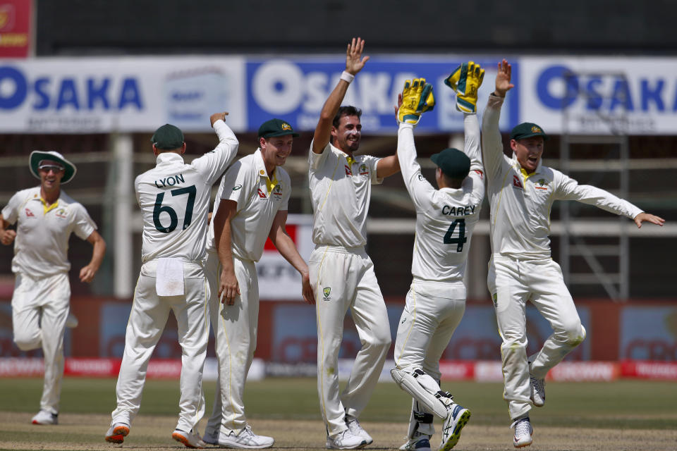Australia's Mitchell Starc, third left, celebrates with teammates after taking the wicket of Pakistan Fawad Alam during the third day of the second test match between Pakistan and Australia at the National Stadium in Karachi, Pakistan, Monday, March 14, 2022. (AP Photo/Anjum Naveed)