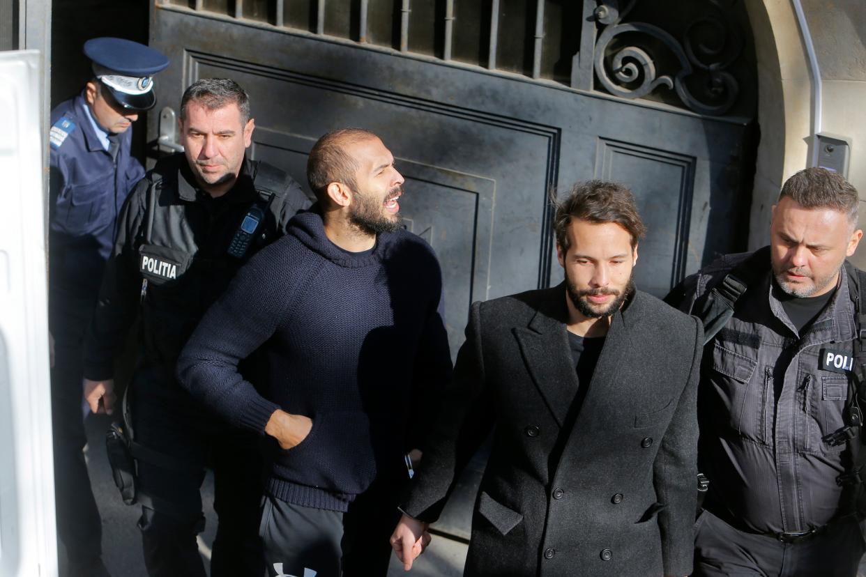 Andrew (centre) and Tristan (second from right) are escorted by police officers after a hearing at the Bucharest Court of Appeal (EPA)