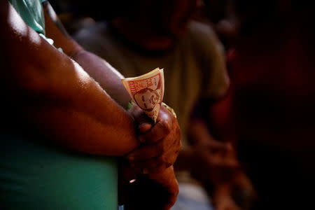 A cockfighting enthusiast holds money during a fight at a cockfighting arena in Moron, central region of Ciego de Avila province, Cuba, February 16, 2017. REUTERS/Alexandre Meneghini