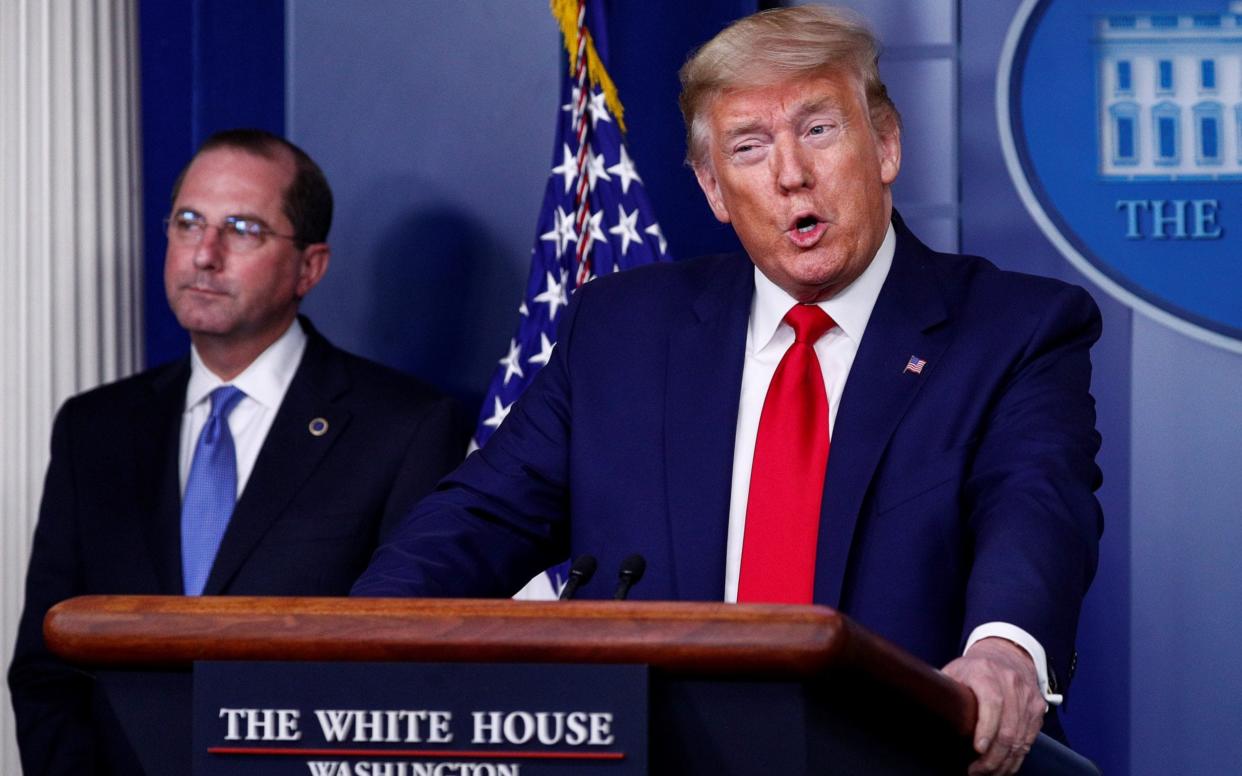 Donald Trump addresses a daily coronavirus task force briefing as Health and Human Services Secretary Alex Azar listens - Reuters