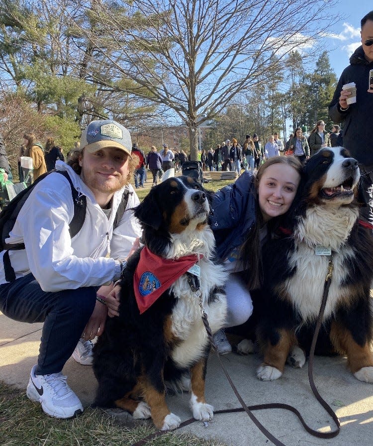Claire Bacarella of Monroe and her boyfriend, Cameron Merrill, both Michigan State University students, visit with Cheryl Wassus’ therapy dogs, Link and Ella B. Wassus of Monroe and three other area dog handlers and their dogs were among those offering support at the Feb. 19 Spartan Sunday.