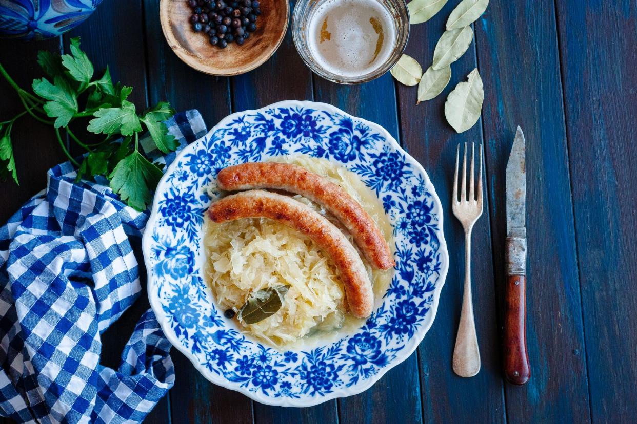 Bratwurst with sauerkraut and beer on blue table