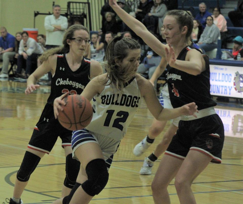 Inland Lakes' Chloe Robinson (12) looks to get to the basket while Cheboygan's Dakota Friday (left) and Bella Ecker (4) defend during a girls basketball game last season. The Lady Chiefs and Bulldogs will square off a Little Caesars Arena in Detroit on Tuesday, Dec. 26.