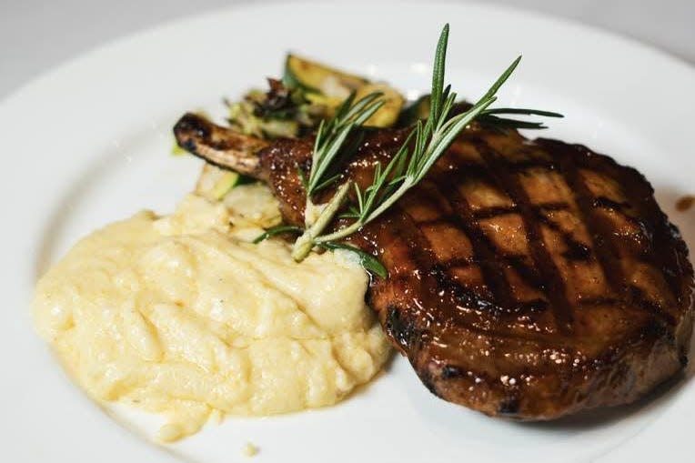 The menu at The Nest in Jensen Beach features a bone-in Duroc pork chop with an apricot-horseradish glaze, served with cheesy polenta and the vegetable of the day.