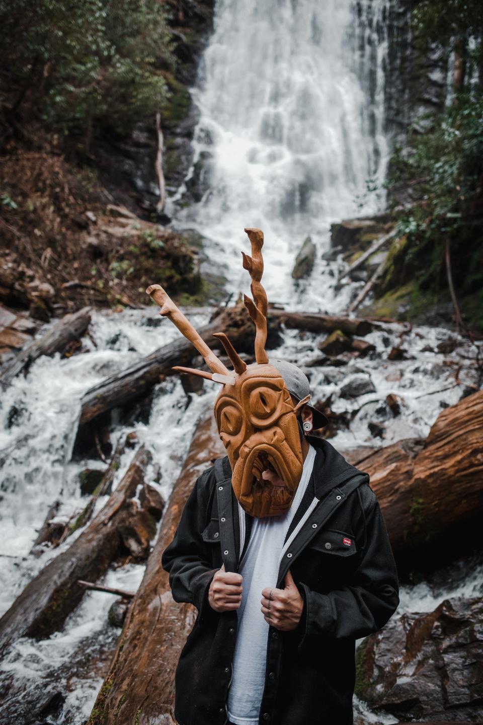 A person wearing a Cherokee booger mask stands in front of a waterfall in a scene from Oklahoma-based Cherokee filmmaker Brit Hensel's short film "ᎤᏕᏲᏅ" (pronounced oo-de-yo-NUH). Hensel's short was recently featured at the 2022 Sundance Film Festival. According to the Sundance Institute, Hensel is the first woman who is a citizen of the Cherokee Nation to direct an official selection at the festival. Photo by Loren Waters (Cherokee Nation)