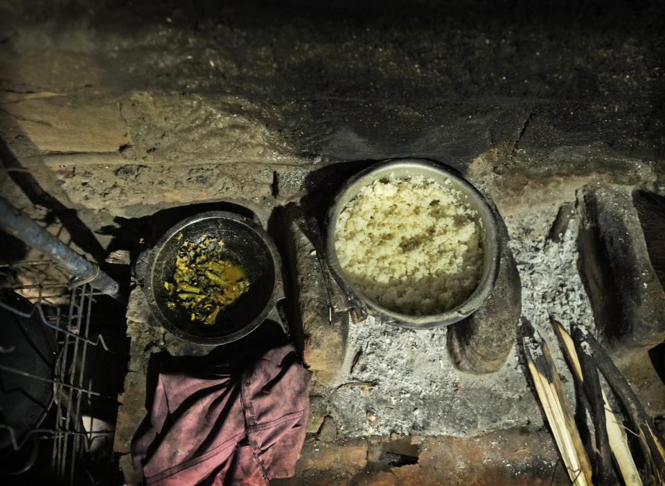 Steamed rice and okra curry, cooked by Ranawaka Bandarage Malkanthi for her three children lie near the hearth in the kitchen at Mahadamana village in Dimbulagala, about 200 kilometres northeast of Colombo, Sri Lanka, Sunday, Dec. 11, 2022. Due to Sri Lanka's current economic crisis families across the nation have been forced to cut back on food and other vital items because of shortages of money and high inflation. Many families say that they can barely manage one or two meals a day. (AP Photo/Eranga Jayawardena)