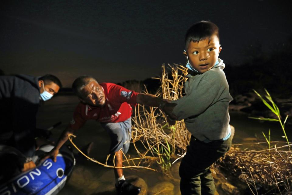 Carlos, 5, from El Salvador is placed on the rocks by a smuggler