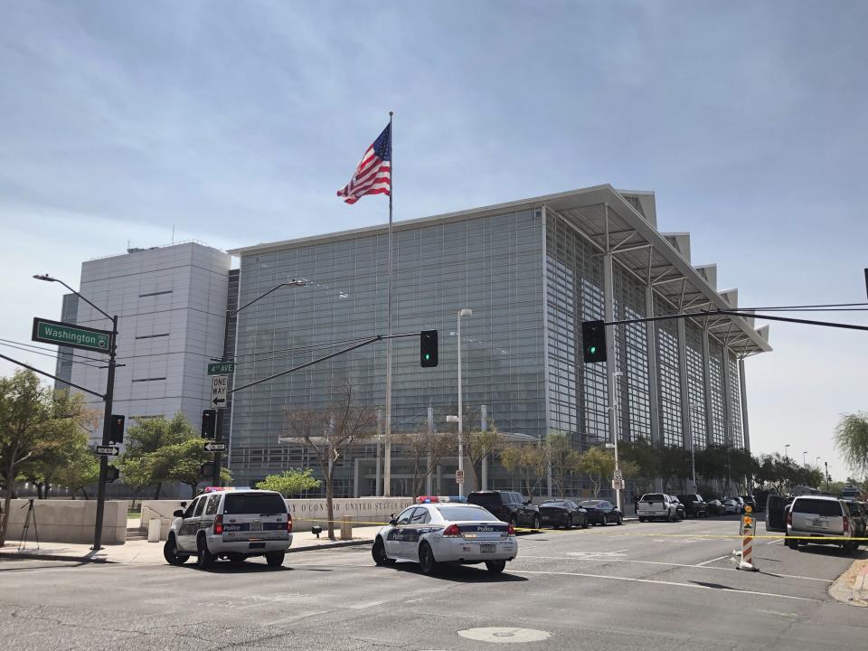 Police cars close off a street outside the Sandra Day O'Connor U.S. Courthouse in Phoenix, on Tuesday, Sept. 15, 2020. A drive-by shooting wounded a federal court security officer Tuesday outside the courthouse in downtown Phoenix, authorities said. The officer was taken to a hospital and is expected to recover, according to city police and the FBI, which is investigating. (AP Photo/Ross D. Franklin)