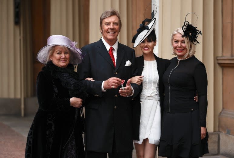 <p>Marty Wilde with his family after getting his MBE in 2017</p> (REX)