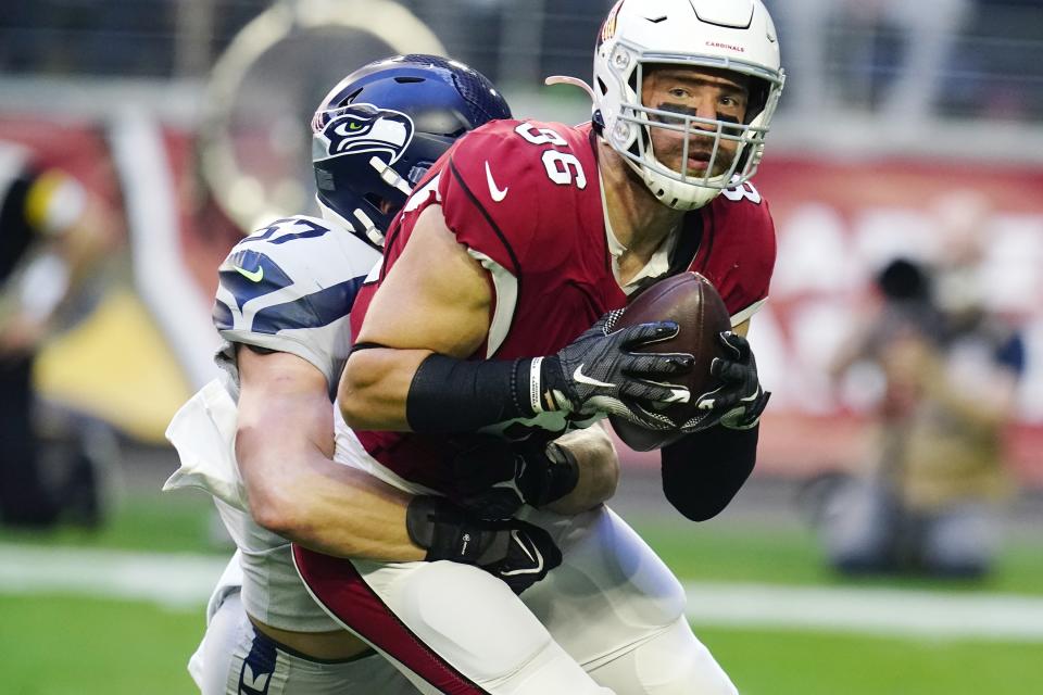 Arizona Cardinals tight end Zach Ertz (86) makes a catch as Seattle Seahawks linebacker Cody Barton (57) holds on for a tackle during the first half of an NFL football game Sunday, Jan. 9, 2022, in Glendale, Ariz. (AP Photo/Darryl Webb)