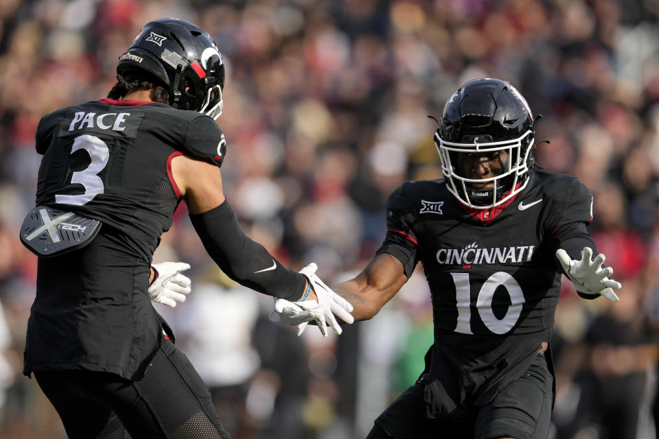 Cincinnati safety Deshawn Pace (3) celebrates with Bryon Threats (10) after sacking Central Florida quarterback John Rhys Plumlee during the first half of an NCAA college football game, Saturday, Nov. 4, 2023, in Cincinnati. (AP Photo/Jeff Dean)