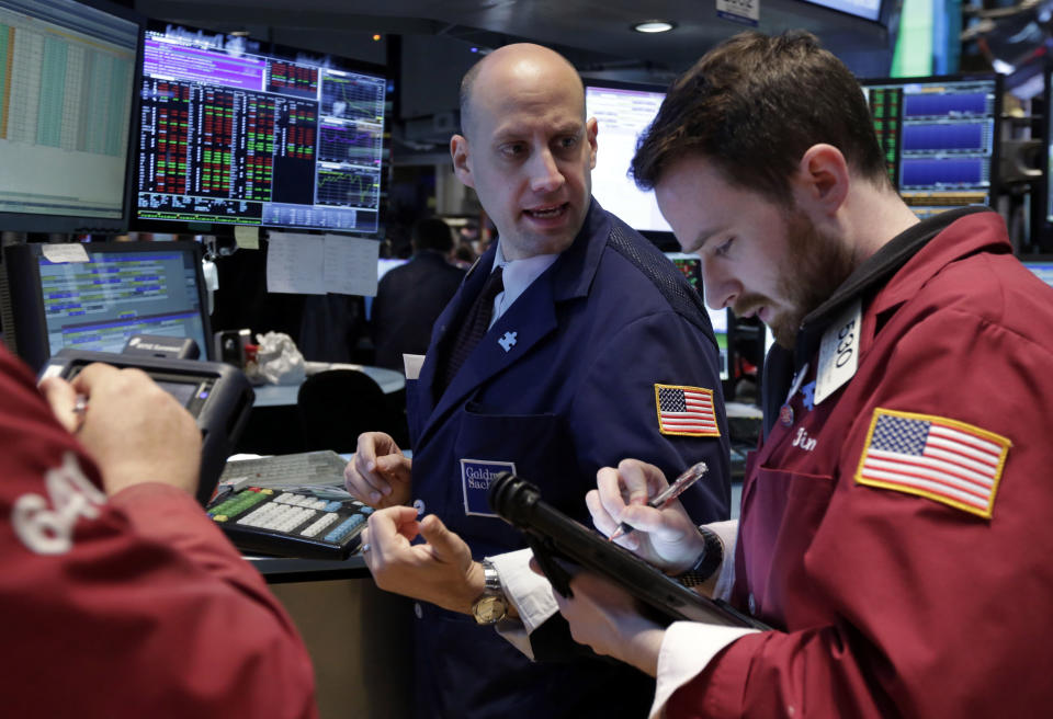 Specialist Meric Greenbaum, center, works at his post on the floor of the New York Stock Exchange Wednesday, April 30, 2014. The stock market is edging lower Wednesday after the U.S. economy slowed more drastically in the first quarter than economists had believed. (AP Photo)