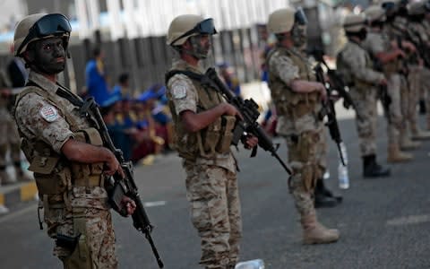 Houthi fighters stand guard in the Yemeni capital Sanaa - Credit: AP