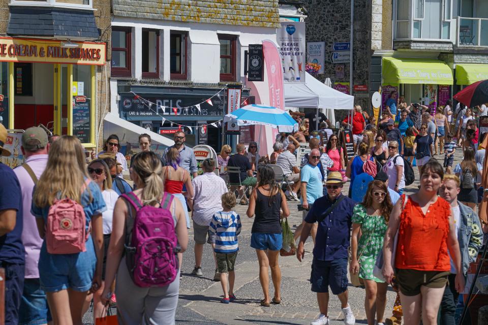 ST IVES, ENGLAND - AUGUST 09: Holiday-makers walk the narrow streets on August 9, 2020 in St Ives, Cornwall, England. The RNLI has called on beachgoers in the south west of England to follow water safety advice and adhere to social distancing. Last week, the charity carried out 30 rescues in one day on just one beach in Cornwall. (Photo by Hugh R Hastings/Getty Images)