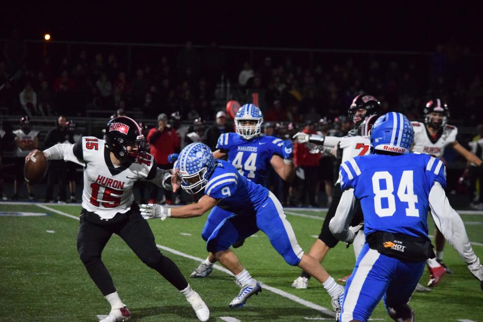 Gibraltar Carlson's Timmy Simons pressures New Boston Huron quarterback Gavin Moczdlowsky during a 38-14 Carlson victory Friday night.