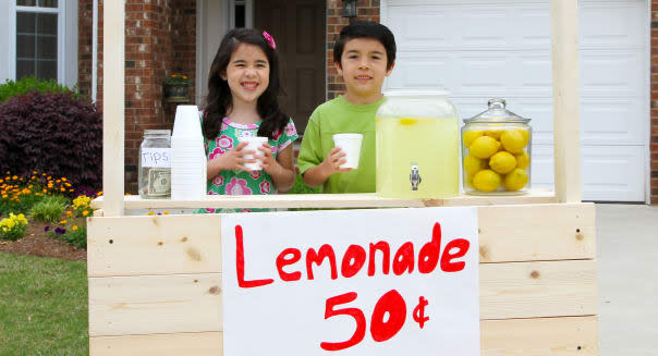 Children selling lemonade in front of their home