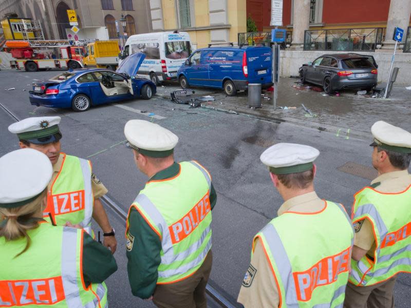 Polizisten stehen an der Unfallstelle. Foto: Peter Kneffel