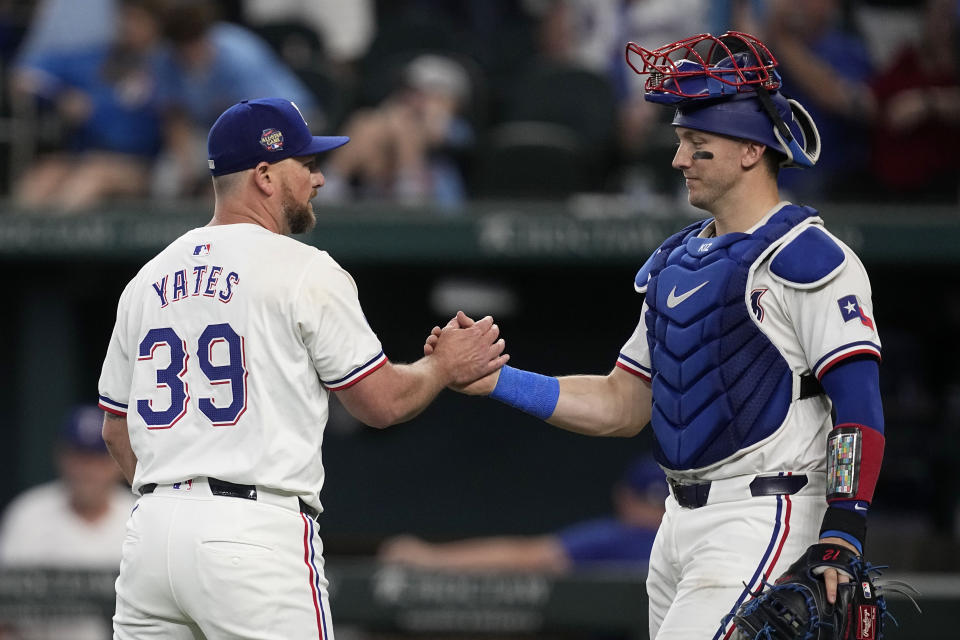 Texas Rangers' Kirby Yates, left, and Andrew Knizner, right, celebrate after their win over the Tampa Bay Rays in a baseball game in Arlington, Texas, Saturday, July 6, 2024. (AP Photo/Tony Gutierrez)