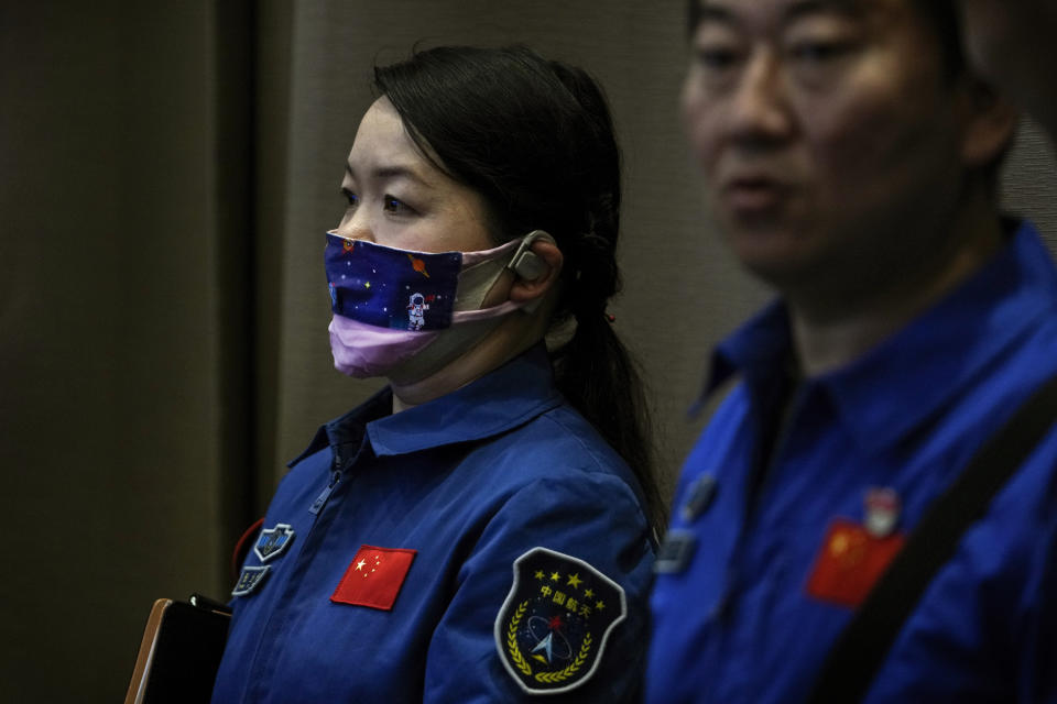 A staff member wearing a face mask depicting a Chinese astronaut in a space as they attend a press conference for the upcoming Shenzhou-18 mission at the Jiuquan Satellite Launch Center in northwest China, Wednesday, April 24, 2024. (AP Photo/Andy Wong)