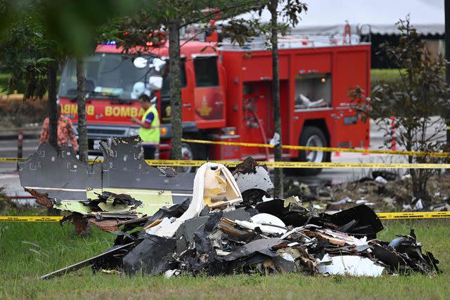 <p>MOHD RASFAN/AFP via Getty Images</p> Debris is pictured at the crash site in Shah Alam on August 18, 2023, a day after a light plane crashed on a street in Malaysia's central Selangor state.