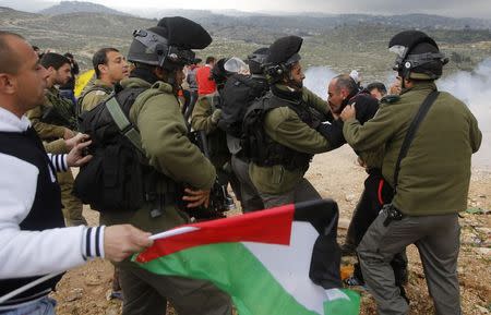 Israeli policemen detain a Palestinian during a demonstration against the closure of the main road in Jabaa area south of the West Bank city of Bethlehem January 17, 2015. REUTERS/Mussa Qawasma