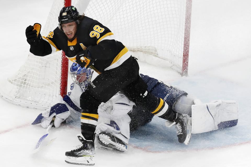 Tampa Bay Lightning's Andrei Vasilevskiy, behind, falls to the ice after blocking a shot by Boston Bruins' David Pastrnak (88) in overtime during an NHL hockey game, Saturday, Dec. 4, 2021, in Boston. (AP Photo/Michael Dwyer)