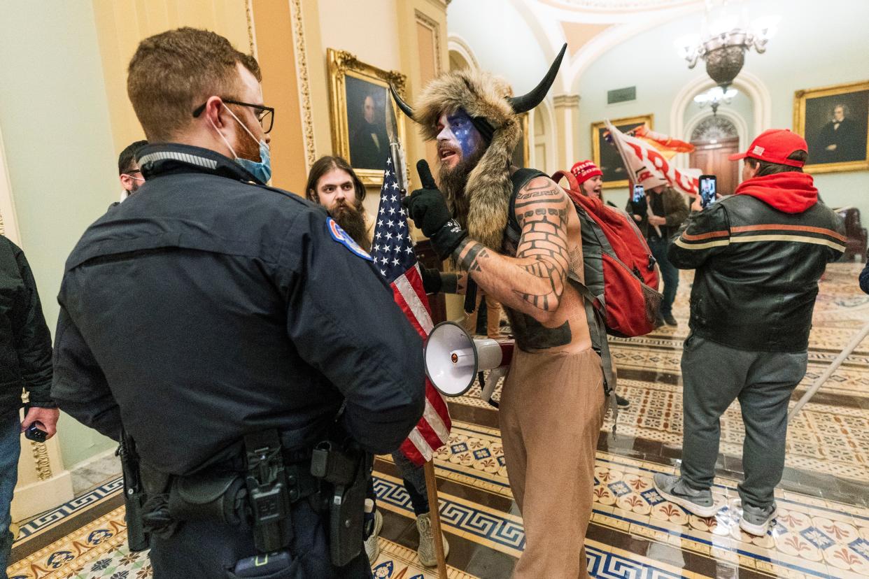 In this Jan. 6, 2021, file photo, rioters who supported President Donald Trump, including Jacob Anthony Chansley, are confronted by U.S. Capitol Police officers outside the Senate Chamber inside the Capitol in Washington. 