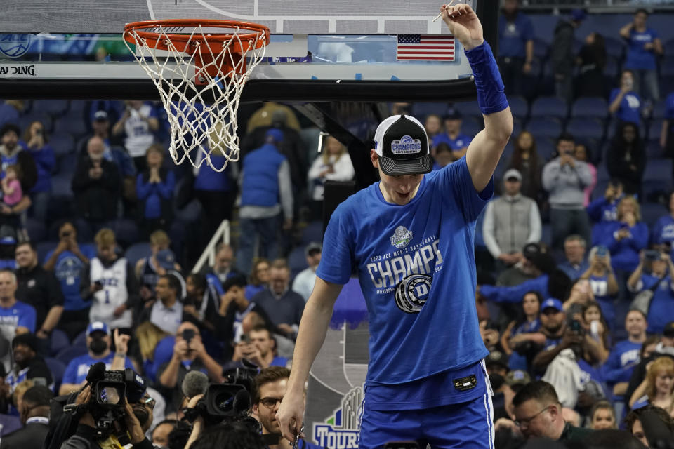 Duke center Kyle Filipowski waves a piece of the net after Duke's win over Virginia in an NCAA college basketball game for the championship of the Atlantic Coast Conference tournament in Greensboro, N.C., Saturday, March 11, 2023. (AP Photo/Chuck Burton)