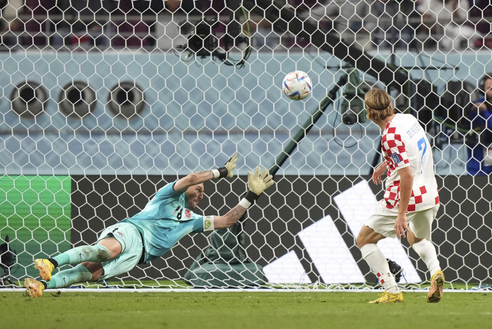 Croatia midfielder Lovro Majer (7) scores past Canada goalkeeper Milan Borjan (18) during the second half of the group F World Cup soccer match at the Khalifa International Stadium in Al Rayyan, Qatar, on Sunday, Nov. 27, 2022. (Nathan Denette/The Canadian Press via AP)