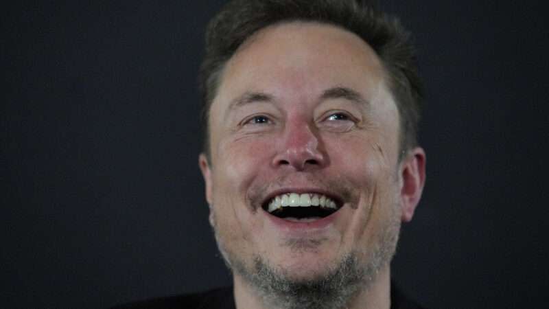 Elon Musk laughing against a dark background