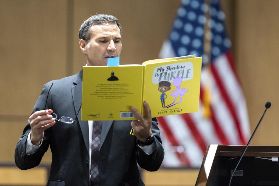 Attorney Craig Goodmark, representing Cobb County teacher Katie Rinderle reads from a copy of the children's book "My Shadow is Purple" during a hearing at the Cobb County Board of Education in Marietta, Ga., Thursday, Aug. 10, 2023. Rinderle is facing termination after reading "My Shadow is Purple," a book about gender identity, to fifth graders. (Arvin Temkar/Atlanta Journal-Constitution via AP)