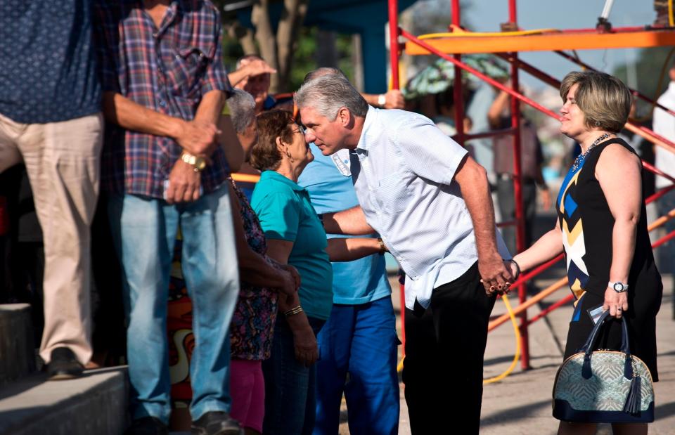 Miguel Díaz-Canel (centro), de la mano de su esposa, Lis Cuesta Peraza, habla con una mujer mientras espera junto a otros votantes en una fila en un centro de votación en los comicios para elegir a los representantes nacionales y provinciales en la Asamblea Nacional, en Santa Clara, Cuba. (AP Foto/Ramón Espinosa, archivo)