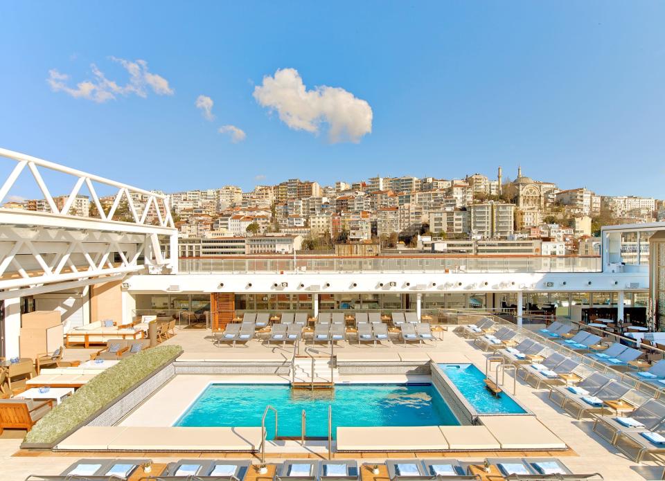 rectangular pool with lounge chairs on all four sides