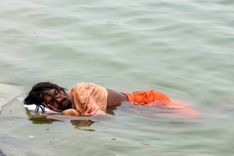 A man in India sleeps in the River Ganges in Varanasi on June 18: much of northern India has been gripped by a brutal month-long heatwave (Niharika KULKARNI)