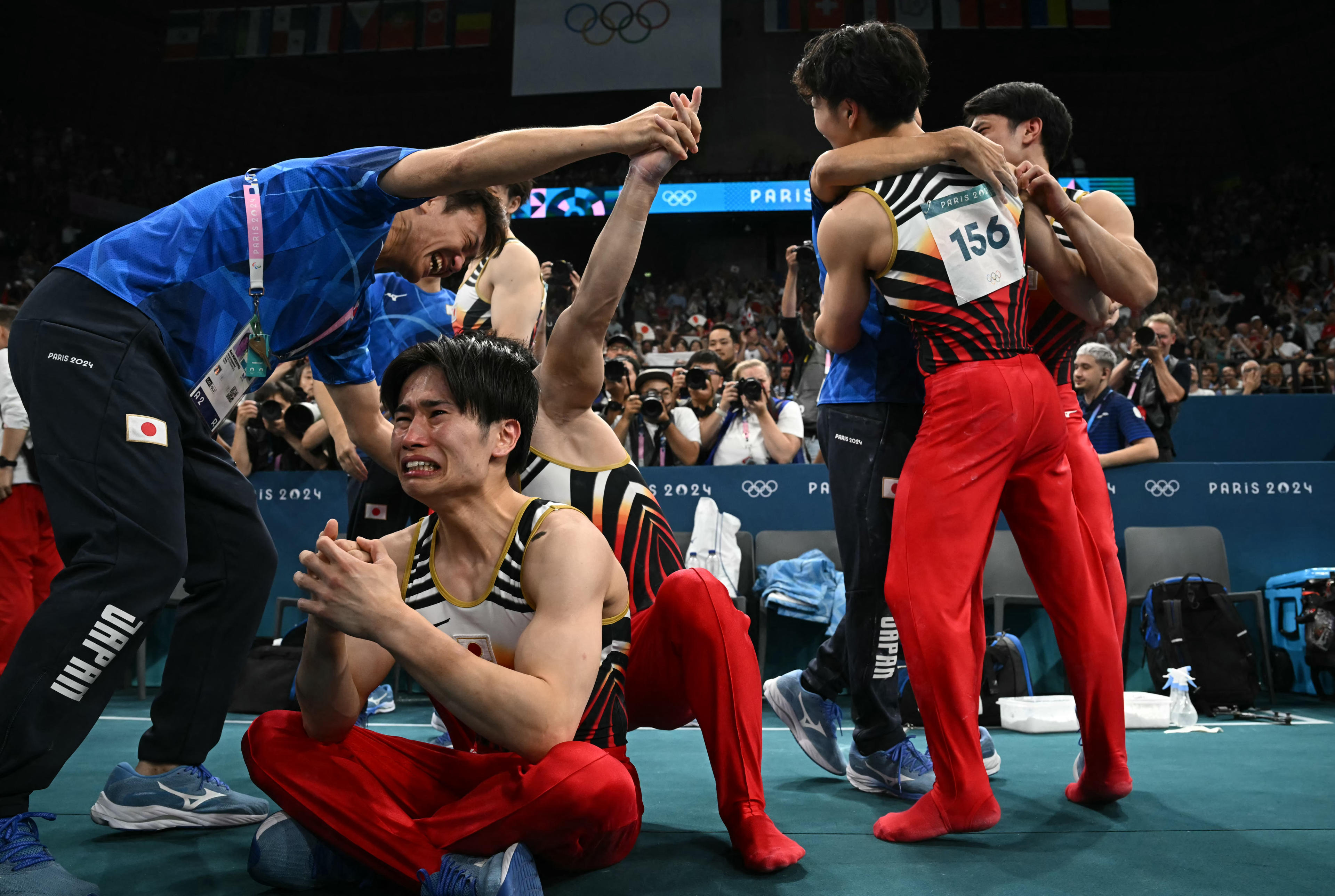 Team Japan celebrates after winning the gold medal in the artistic gymnastics men's team final during the Paris 2024 Olympic Games at the Bercy Arena in Paris, on July 29, 2024. (Photo by Paul ELLIS / AFP)