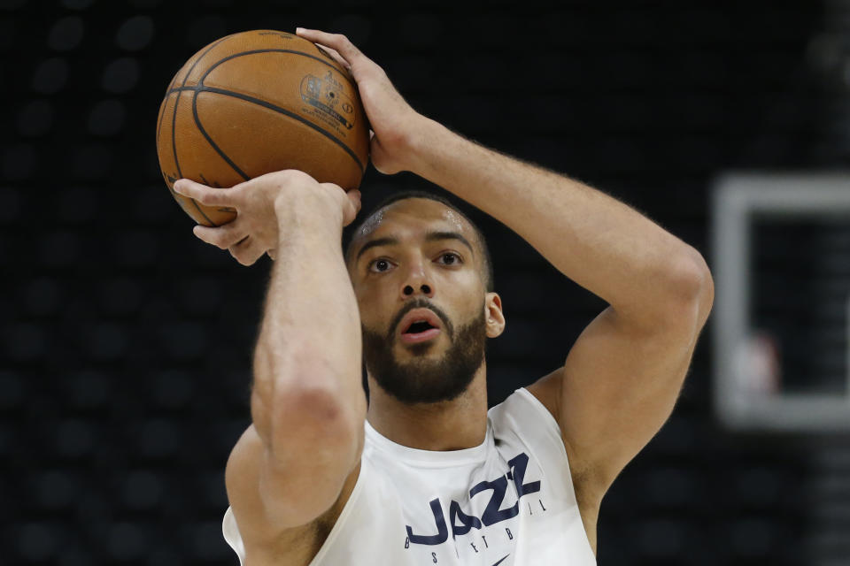 FILE - In this Feb. 24, 2020, file photo, Utah Jazz center Rudy Gobert shoots during practice before a NBA basketball game against the Phoenix Suns in Salt Lake City. Gobert is standing tall, even after having coronavirus and dealing with an enormous amount of scorn after being diagnosed. He was the first NBA player to test positive for the virus and that prompted many to blame him for the league's shutdown in response to the pandemic. (AP Photo/Rick Bowmer, File)