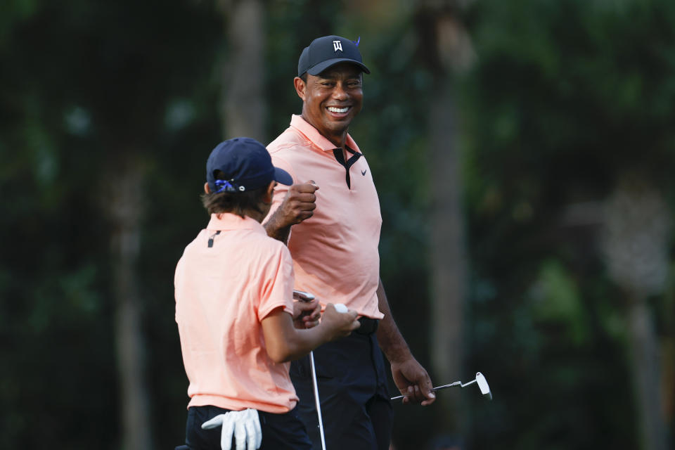 Tiger Woods reacts with his son Charlie Woods on the 16th green during the first round of the PNC Championship golf tournament Saturday, Dec. 18, 2021, in Orlando, Fla. (AP Photo/Scott Audette)