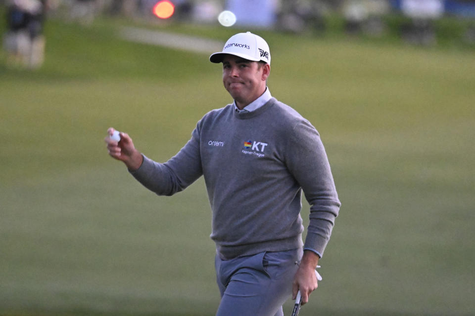 Luke List holds the ball up after hitting a birdie putt on the 18th hole of the South Course during the final round of the Farmers Insurance Open golf tournament, Saturday, Jan. 29, 2022, in San Diego. (AP Photo/Denis Poroy)