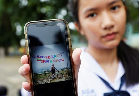 A student shows a photo of her classmate Prachak Sutham, 13, who is a member of an under-16 soccer team that went missing with their coach at a flooded cave, in Mae Sai Prasitsart school in the northern province of Chiang Rai, Thailand, July 2, 2018. REUTERS/Soe Zeya Tun/Files