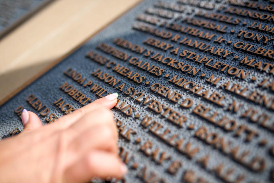 Ashley Sylvester shows April 14 where her late husband, Sgt. Jason A. Sylvester, is listed on the Veterans Wall of Honor at Veterans Memorial Park in Moore.