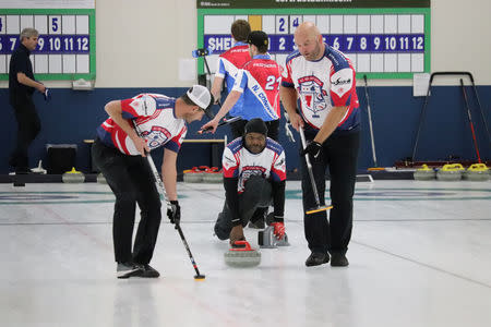 Former Tennessee Titans linebacker Keith Bulluck throws a stone while teammates Marc Bulger and Michael Roos prepare to sweep during the USA Curling Men's Challenge Round in Blaine, Minnesota, U.S., January 3, 2019. All Pro Curling/Handout via REUTERS