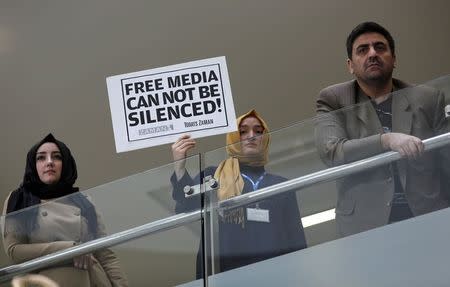 A Zaman journalist holds a placard at the headquarters of Zaman daily newspaper in Istanbul December 14, 2014. REUTERS/Murad Sezer