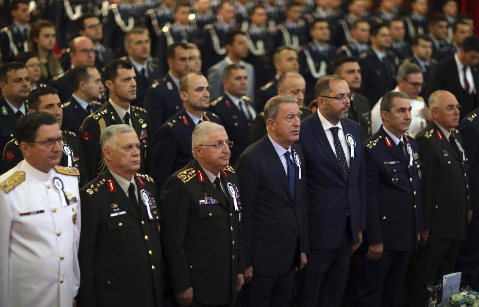 Turkey's Defense Minister Hulusi Akar, front center, flanked by Turkish army's top commanders before he speak at the National Defence University, in Istanbul, Wednesday, Oct. 9, 2019. Akar says preparations for an expected Turkish incursion into Syria are continuing. (Turkish Defense Ministry via AP, Pool)