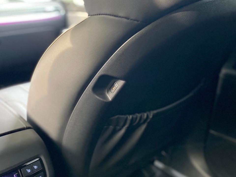 A USB-C charger plug is located on the back of the front passenger seat of a Hyundai Palisade SUV.