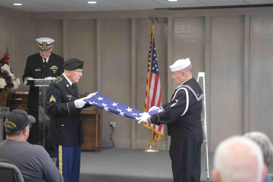 Two members of Volleys for Veterans demonstrate the proper folding of the American flag and its meanings Saturday at the Texas Panhandle War Memorial Center in Amarillo.