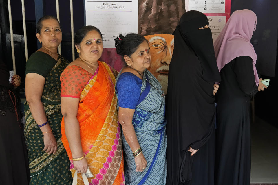 Women line up to cast their votes at a polling station set up at government run school in Bengaluru, India, Wednesday, May 10, 2023. People in the southern Indian state of Karnataka were voting Wednesday in an election where pre-poll surveys showed the opposition Congress party favored over Prime Minister Narendra Modi's governing Hindu nationalist party. (AP Photo/Aijaz Rahi)