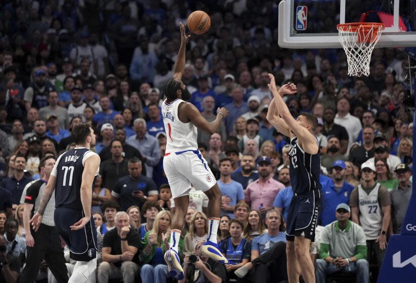 Los Angeles Clippers guard James Harden (1) lofts a shot over Dallas Mavericks forward Maxi Kleber as Mavericks' guard Luka Doncic (77) looks on during the second half of Game 4 of an NBA basketball first-round playoff series, Sunday, April 28, 2024, in Dallas. (AP Photo/Jeffrey McWhorter)