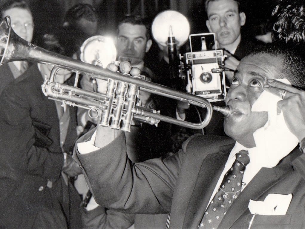 Louis Armstrong in London, 1956, with future biographer John Chilton far left (Supplied)