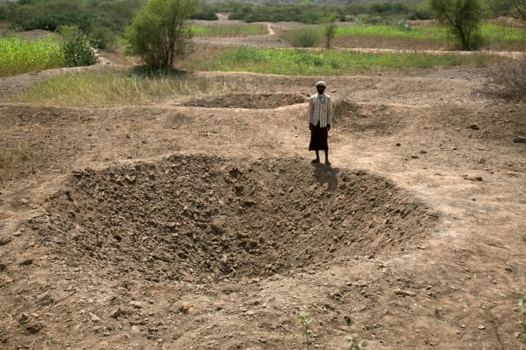 A Yemeni stands next to a crater following reported Saudi-led coalition air strikes on October 27, 2016 in Khamis Bani Saad district in al-Mahwit governorate